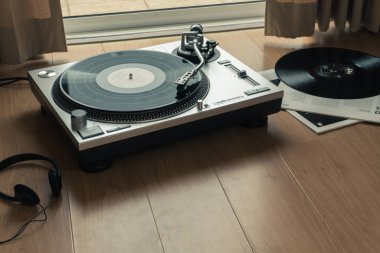 Bangkok, Tayland - 22 Temmuz 2018: Audio-technica pikap ile Bill Evans Trio vinil plak, Pazar At Village Vanguard albüm. Ahşap zemin üzerinde bir kulaklık Ella ve Louis vinil kayıtla.