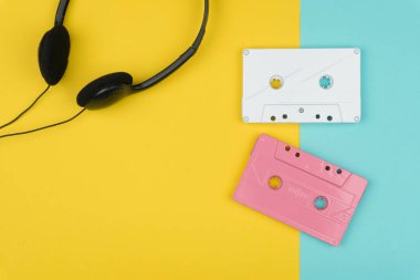 sarı ve mavi zemin üzerine beyaz ve pembe ses Kaset şerit ve siyah bir kulaklık üstten görünüm