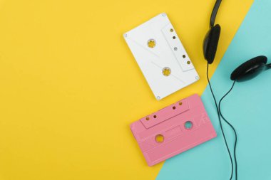 sarı ve mavi zemin üzerine beyaz ve pembe ses Kaset şerit ve siyah bir kulaklık üstten görünüm