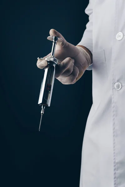 Lekarz Trzymając Strzykawkę Duże Stali Nierdzewnej Ciemnym Tle — Zdjęcie stockowe