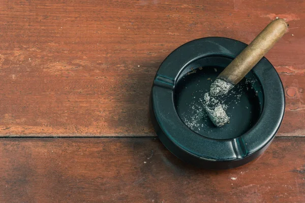 在木桌上关闭古巴雪茄和黑色陶瓷烟灰缸 — 图库照片
