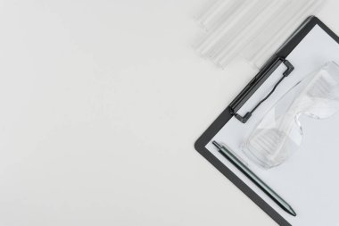 laboratuvar aletleri en iyi görünümü. Kalem ve koruyucu gözlük, beyaz masa üzerinde test tüpleri ile bir pano