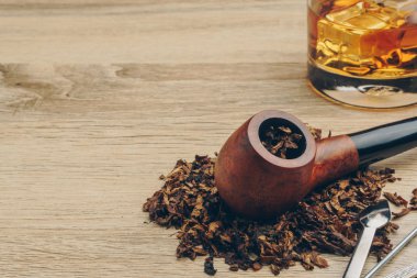 Tütün, bir boru dış müdahale aracı ve bir bardak viski ahşap masa üzerinde yasaktır borunun yakın çekim