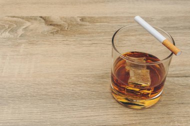 bourbon viski buz küpleri ve ahşap masa üzerinde bir sigara bir bardak
