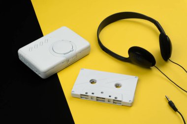 Beyaz Ses kaset ve sarı ve siyah arka plan üzerinde siyah bir kulaklık ile beyaz bir taşınabilir kaset çalar