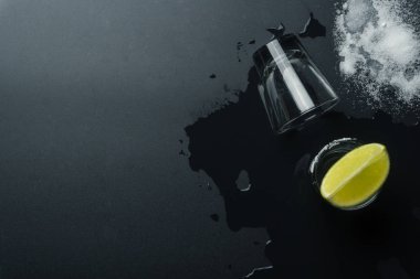 üstten görünüm gümüş tekila gözlük, kireç dilim ve tuz ıslak masaya vurdu