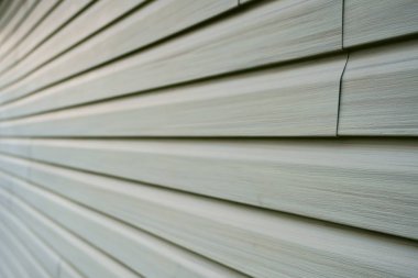 Tiles of vinyle covering an exterior wall of a residential home in North America in order to isolate the house from the cold winter season. clipart