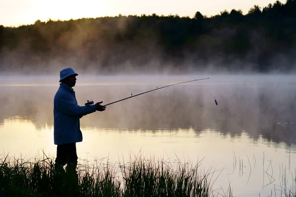 肖像画 一位50岁的高加索渔民 在有雾的湖面上 就在日出前的清晨 — 图库照片