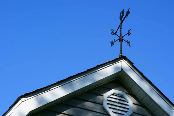 Die Vier Himmelsrichtungen Auf Dem Dach Einer Scheune Mit Blauem lizenzfreie Stockbilder