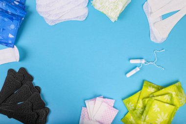 Adet tampon ve yastıkları mavi bir arka plan üzerinde. Adet döngüsü. Hijyen ve koruma. Düz yatıyordu. Kopya alanı ile metin için.