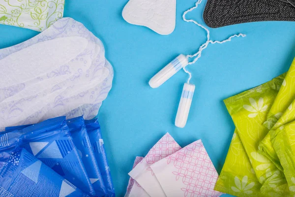 Adet tampon ve yastıkları mavi bir arka plan üzerinde. Adet döngüsü. Hijyen ve koruma. Düz yatıyordu