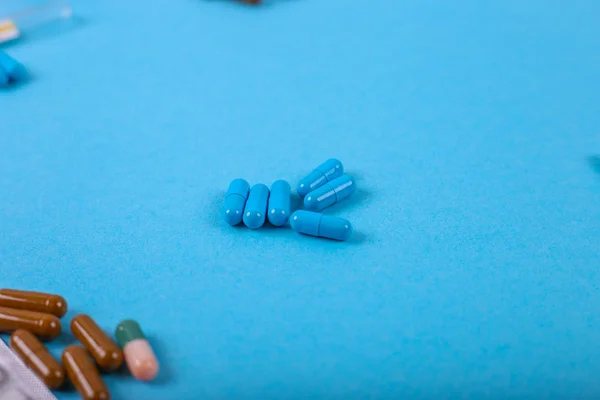 Píldoras de medicina sobre fondo azul — Foto de Stock