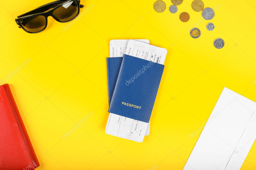 Two travelers passports with boarding passes for the plane on yellow background. Top view.