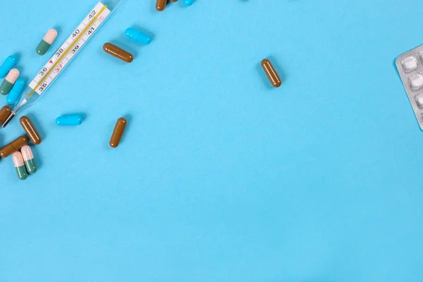 Vista superior de las píldoras de la medicina sobre fondo azul. Puesta plana — Foto de Stock