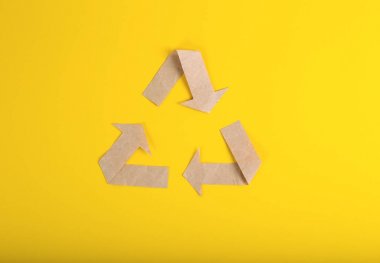 sarı arka plan üzerinde sarı arka plan üzerinde geri dönüşüm logosundan yeniden kağıt dokusu