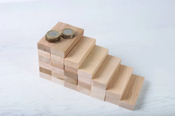 Stacked blocks with coins on grey table. Concept of career