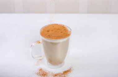 Ahşap masada tarçın ile kahve latte Cam fincan