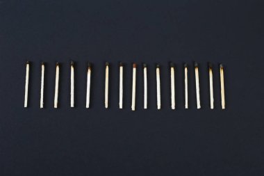 Siyah arka plan üzerinde merkezinde yeni yanmış maçlar bir satır