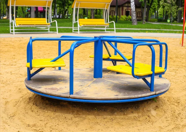 Yuvarlak park kum üzerinde salıncak döner. Çocuk bahçesi