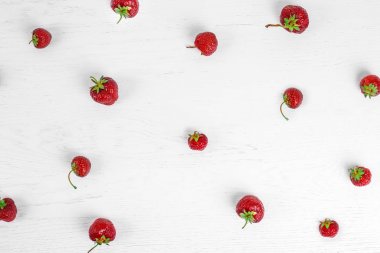 Beyaz ahşap arka planda çilek renkli deseni. Üst görünüm