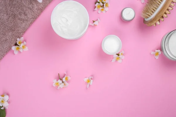 Crema cosmetica e mazzo di fiori su sfondo rosa. Spazio per testo — Foto Stock
