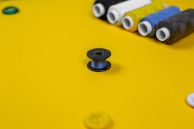 sarı bir arka plan üzerinde iplik ile bobin. Close.