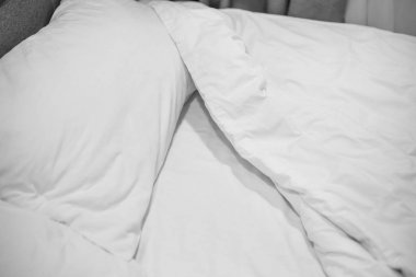 Beyaz çarşaf ve yastık doğal taş duvar Oda arka planda, dağınık yatak konsepti yatak takımları kapatın