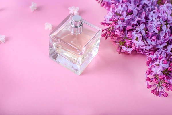 Μπουκάλι άρωμα με λουλούδια σε ροζ φόντο — Φωτογραφία Αρχείου