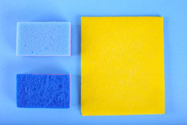 Vista superior de esponjas de limpeza no fundo azul — Fotografia de Stock