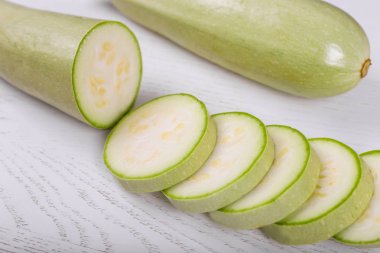 Beyaz ahşap arka plan üzerinde taze kesilmiş kabak.