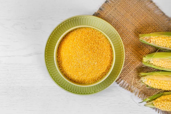 Mısır groats ve tohumlar, ahşap masa üzerinde mısır koçanları. Üst te. Yakın çekim