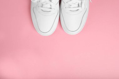 Pembe arka planda şık yaz beyaz koşu ayakkabıları, üst görünümü. Metin için kopyalama alanı ile düz yatıyordu