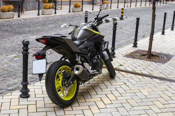 Beautiful black matte motorbike on the background of the old city — Stock Photo, Image