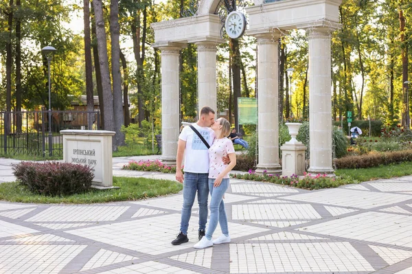Feliz pareja besos en el fondo de un hermoso parque. Joven marido y mujer —  Fotos de Stock