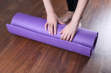 Spor antrenmanından önce ya da sonra mor spor salonunda ya da yoga stüdyosunda egzersiz yapan genç bir kadın. Sağlıklı alışkanlıklar, formda kalmak, kilo vermek. Fotoğraf yogasını kapat.