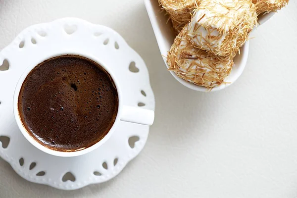 Ezilmiş fındık Türk lokumu üstten görünüm arka plan ile tepesinde şurup pişmiş Shredded hamur ile Türk kahvesi