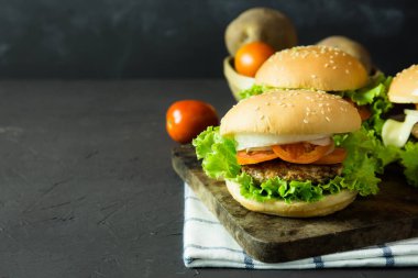 domuz eti, soğan, domates, marul ve peynir rustik koyu arka plan üzerinde ev yapımı hamburger.