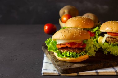 domuz eti, soğan, domates, marul ve peynir rustik koyu arka plan üzerinde ev yapımı hamburger.