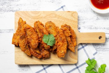 Ahşap tahta üzerinde kızarmış tavuk kanatları. ekmekli çıtır tavuk hizmet ile