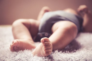 Yeni doğan Asya bebek beyaz tüylü kumaş üzerinde uyku ayak