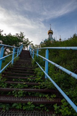 dağda duran tapınağa giden basamaklar ile mavi metal merdiven