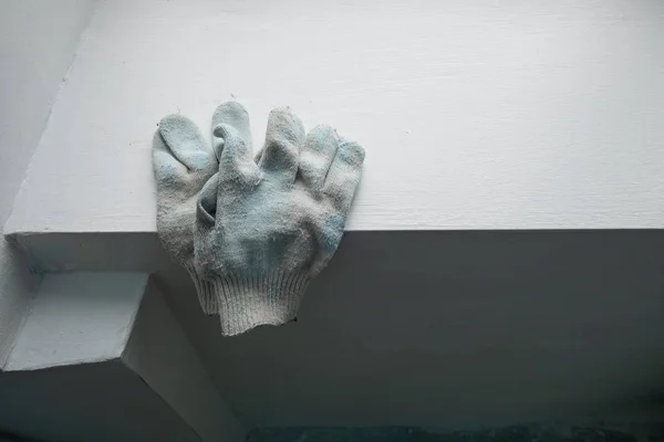 Alçıressamın eldivenleri, inşaat aşamasındaki evin plastik pencereleriyle pencere nin üzerinde yatıyor. Bir apartmanda boyama işleri