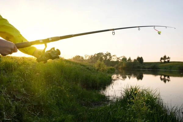 Vrouwelijke Handen Houden Een Hengel Het Meer Bij Zonsondergang Zonsondergang — Stockfoto