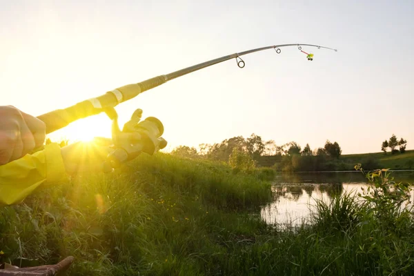 日落时分 女性手在湖上拿着一根钓鱼竿 日落钓鱼 — 图库照片