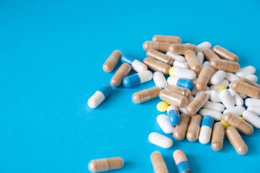 Bir sürü farklı hap mavi arka planda..