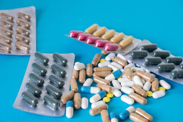 packs of pills lie on a blue background. capsules on blue background