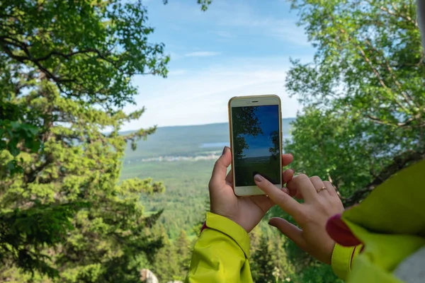 Bir adam telefonda doğayı fotoğraflar. Turizm ve Instagram