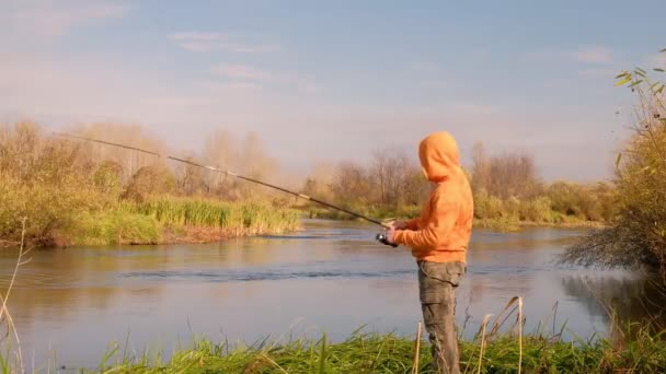Ψαράς που ψαρεύει στο ποτάμι το φθινόπωρο — Αρχείο Βίντεο