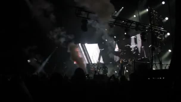 Das Publikum im Konzert winkt mit den Händen, auf der Bühne eine Lichtshow, ein Konzert — Stockvideo