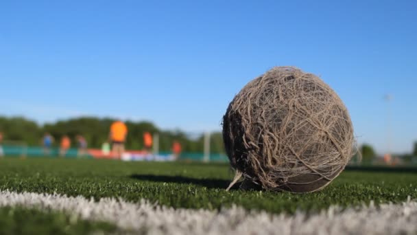 Gammal shabby bollen ligger på fotbollsplan — Stockvideo